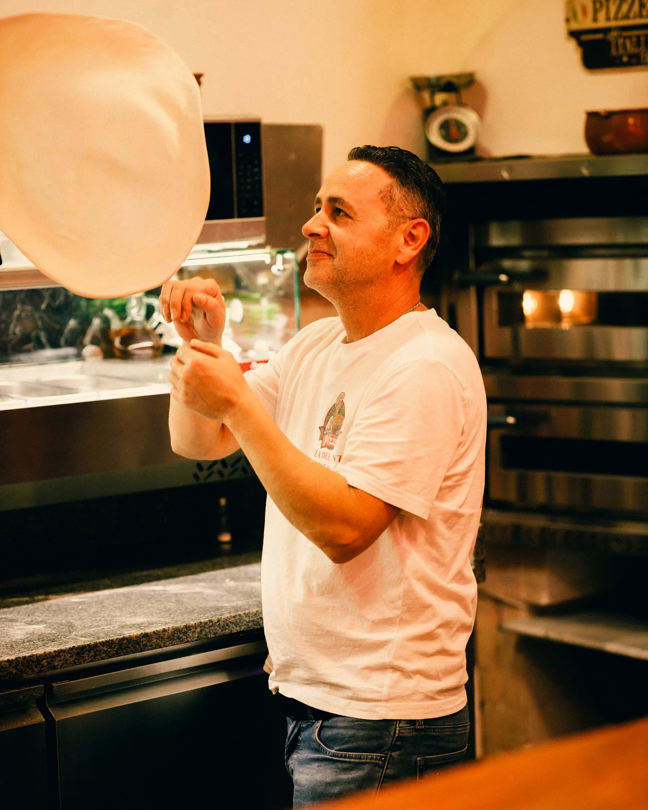 Le pizzaiolo lance la pâte en l'air
