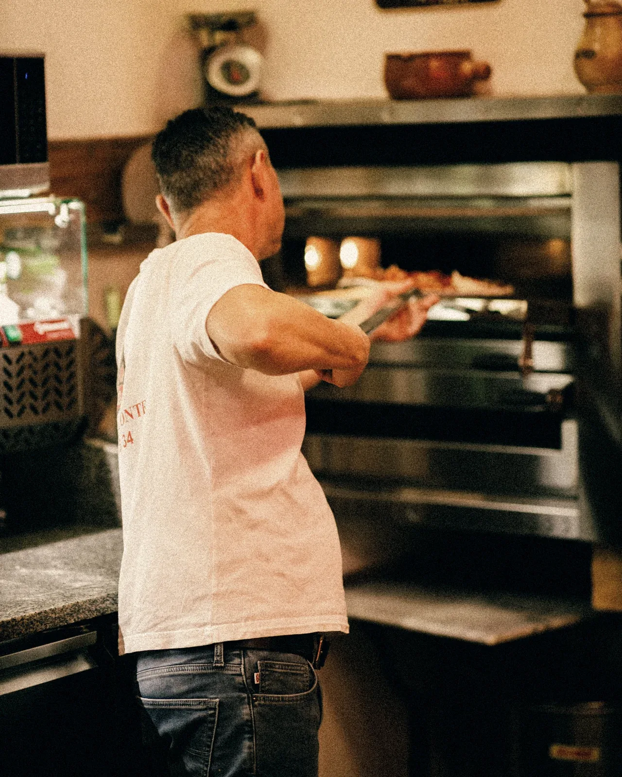 Le pizzaiolo enfourne une pizza