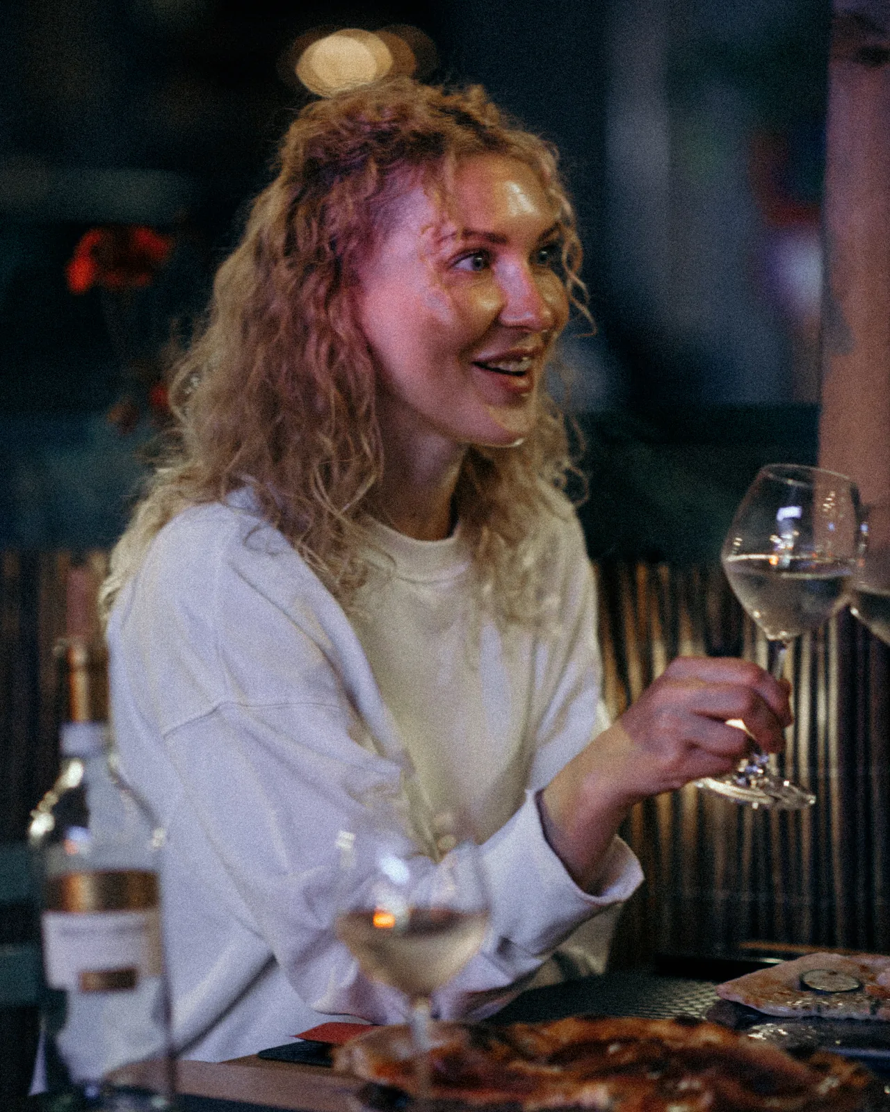 Une cliente, un verre de vin blanc à la main